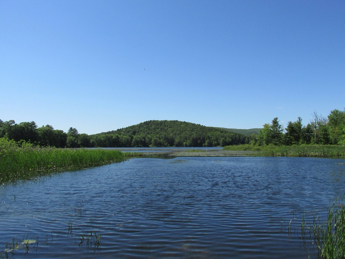 Leverett Pond in Leverett, Massachusetts, with wooded hills in the background.