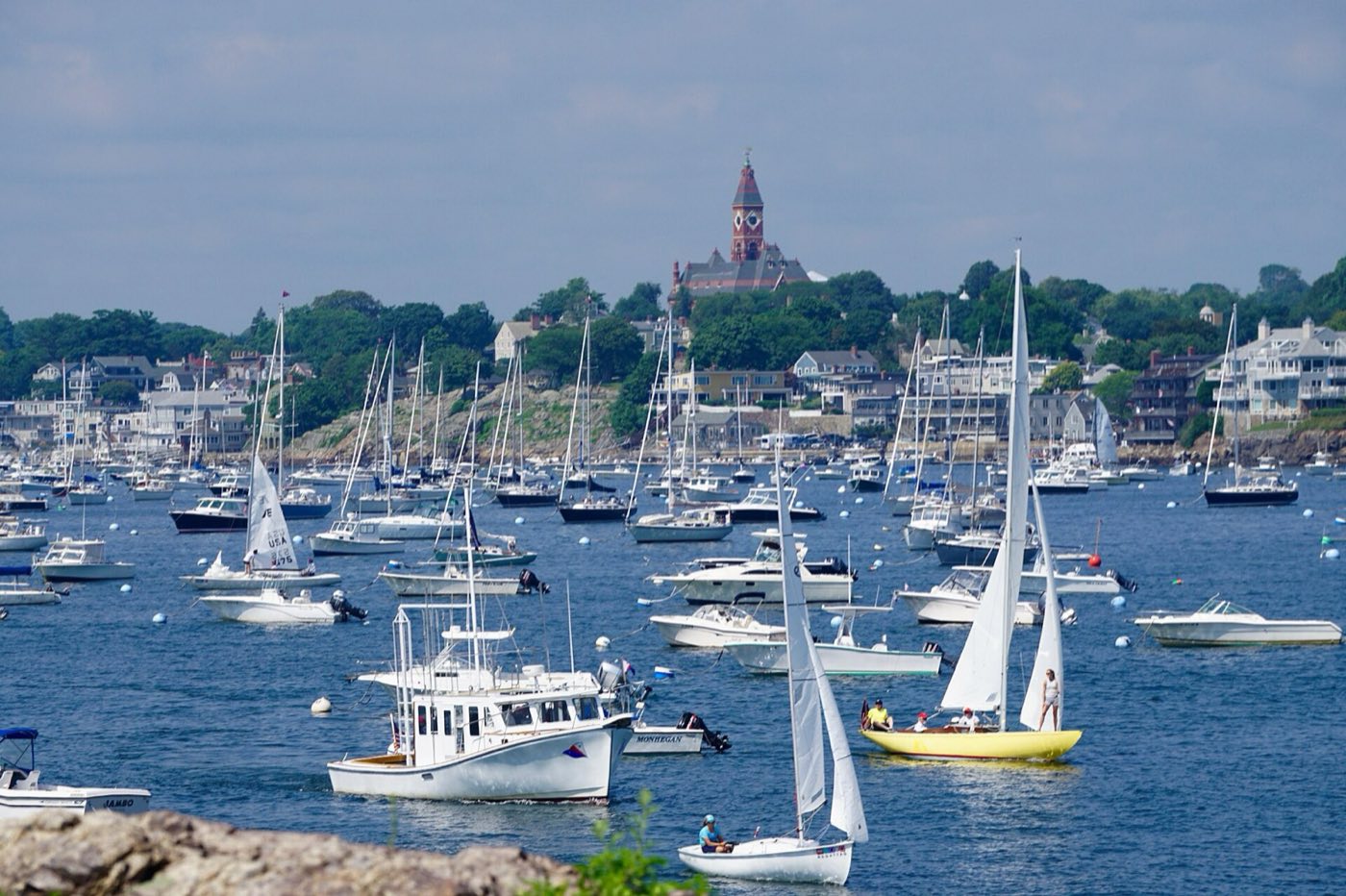 Sailboats and moorings in Marblehead Harbor with the Abbot Hall clock tower visible on the hill above town.