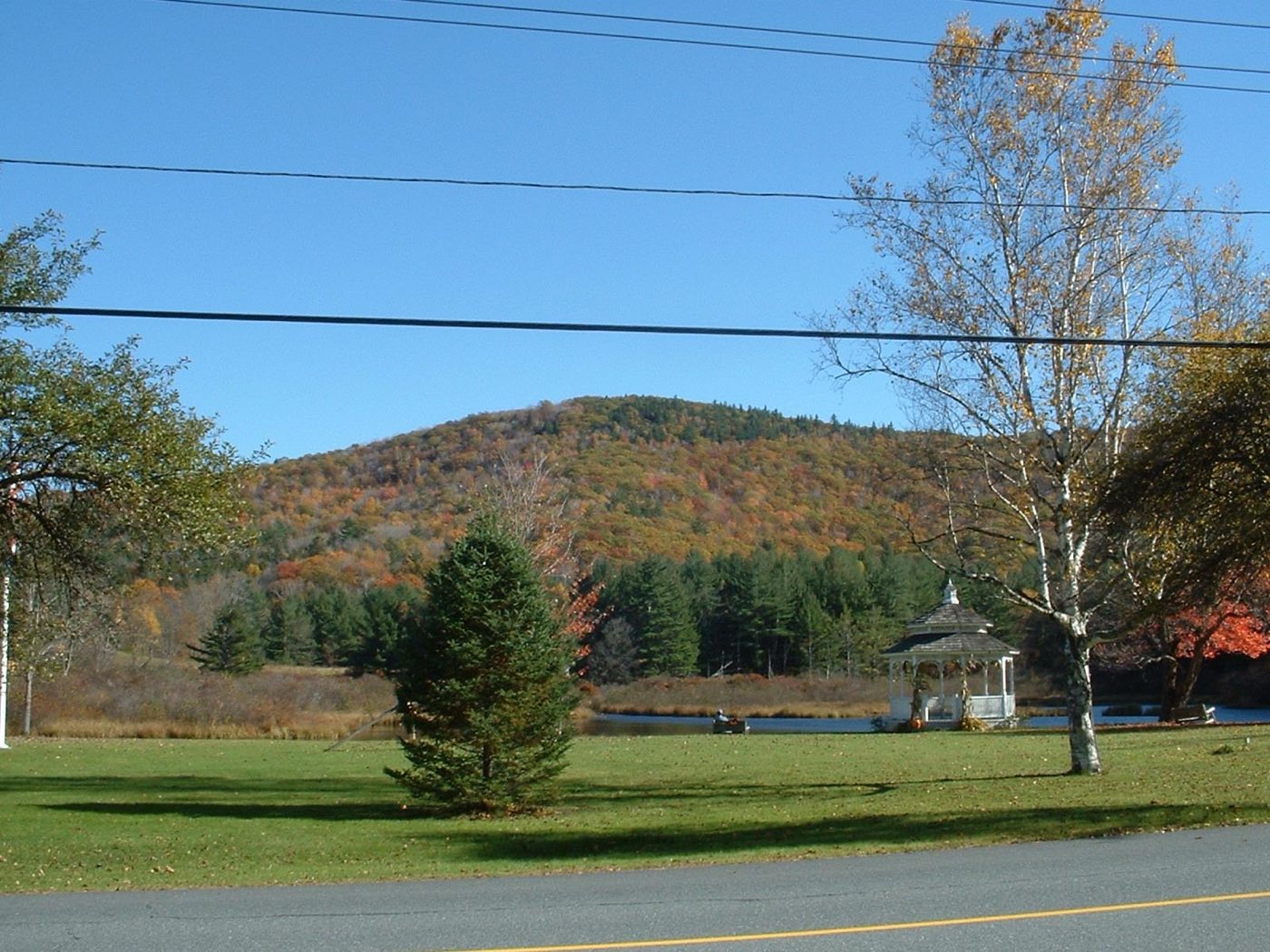 Adams Mountain rising behind Mill Pond and the town common gazebo in Rowe, Massachusetts, in autumn.