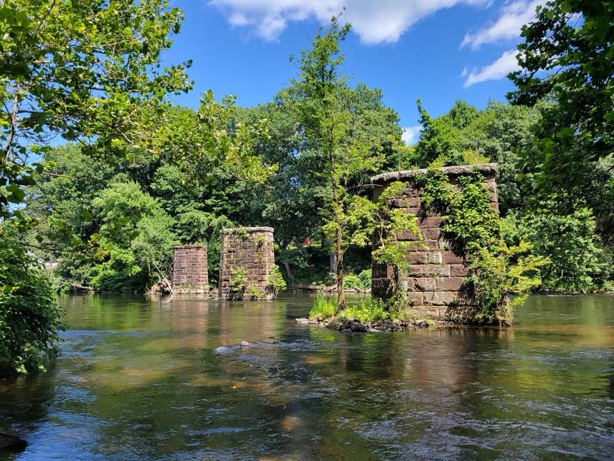 Old stone bridge piers standing in the Farmington River at Tariffville
